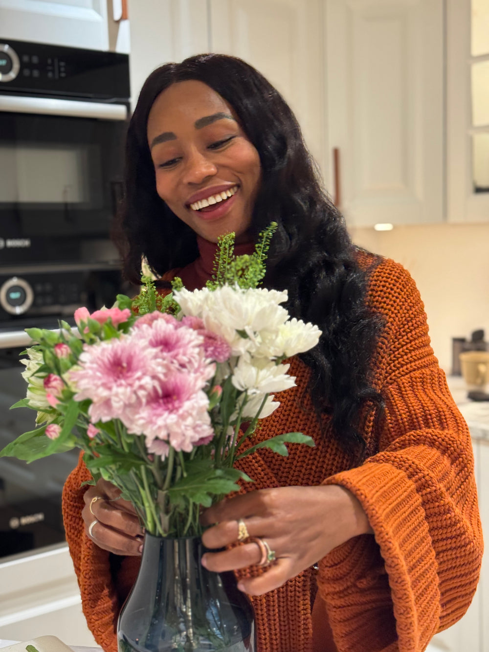 Woman holding a bouquet of flowers in a kitchen