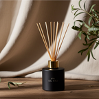 Black diffuser with gold accents on a wooden surface with a neutral background